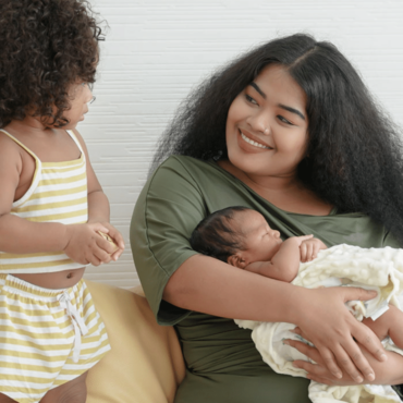mom-long-hair-holding-newborn-smiling-at-toddler@2x mom-long-hair-holding-newborn-smiling-at-toddler@2x