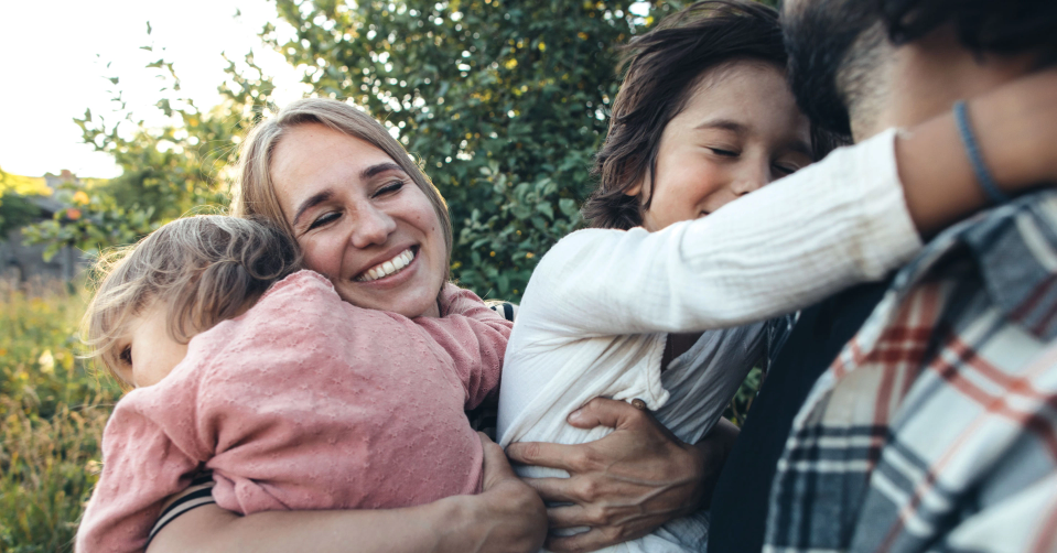 happy-family-outside-smiling-hugging